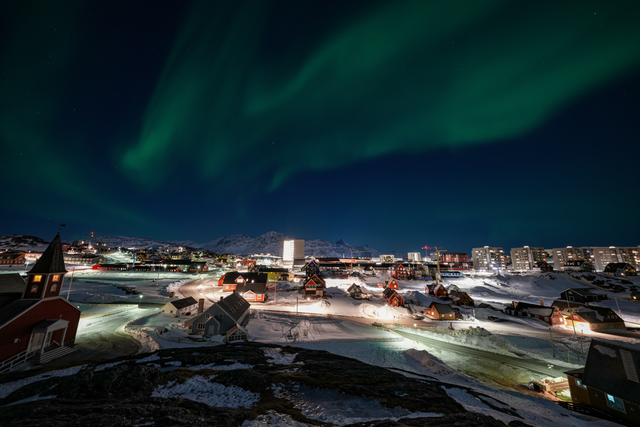 The northern lights shining bright in the night sky above Nuuk in Greenand. (Accessed via Wikimedia Commons.)  