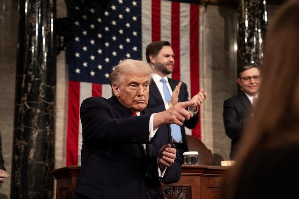 President Trump seen pointing, while Vice President JD Vance is clapping in the background.