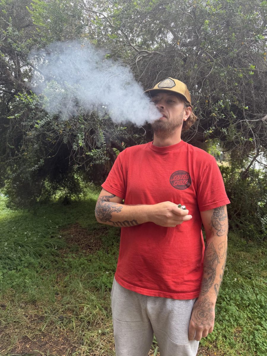 Man smoking in a grassy area